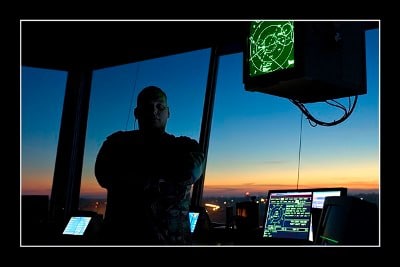 An Air Traffic Controller standing in front of a computer screen at dusk as part of "So You Want My Job" series.