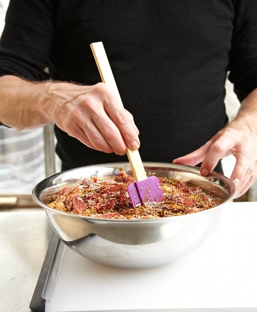 Shot18_BeefJerkyProcess_109 Homemade beef jerky seasoning meat in large bowl with spatula.